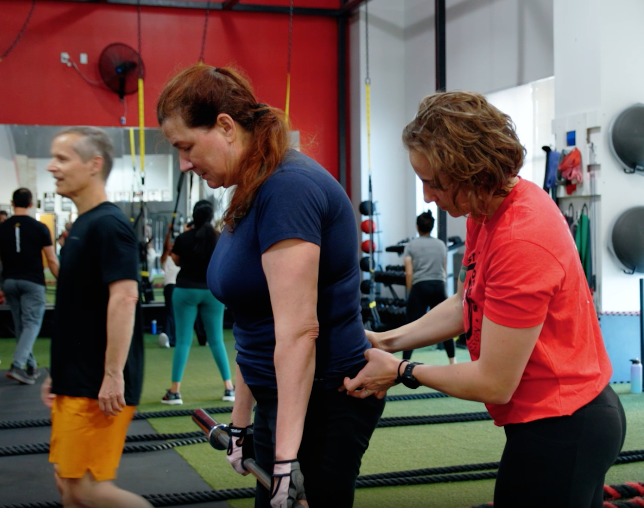Dr. Morgan, personal trainier and physical therapist in Pflugerville, teaching correct form to a client.