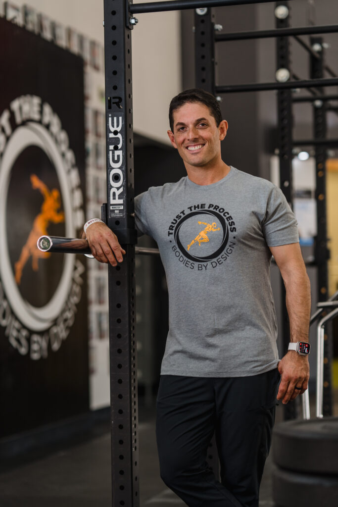 Pflugerville personal trainer, Fred Sassani, leaning on a barbell inside the gym in Pflugerville called Bodies By Design.